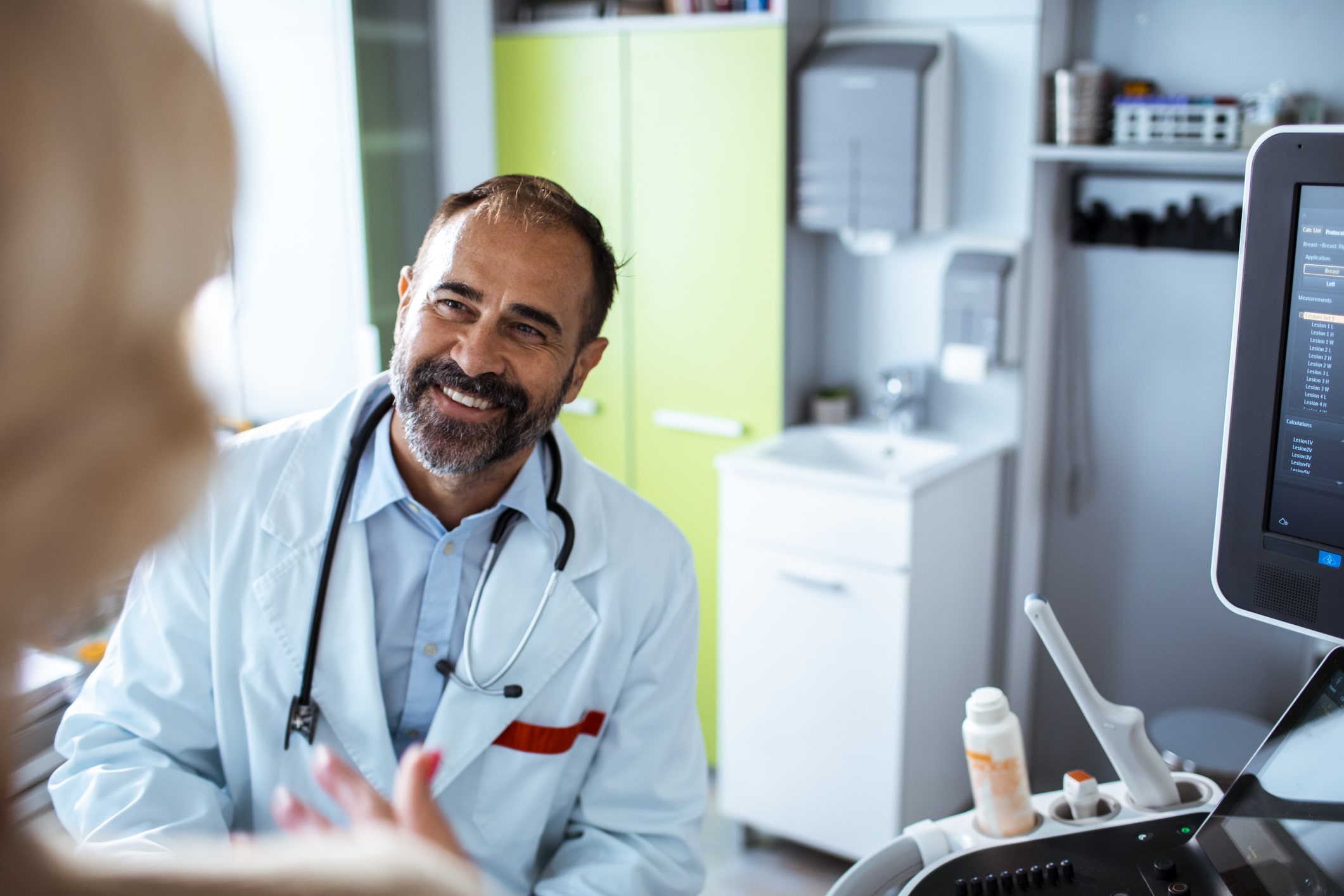 A healthcare worker smiling in conversation with another person.